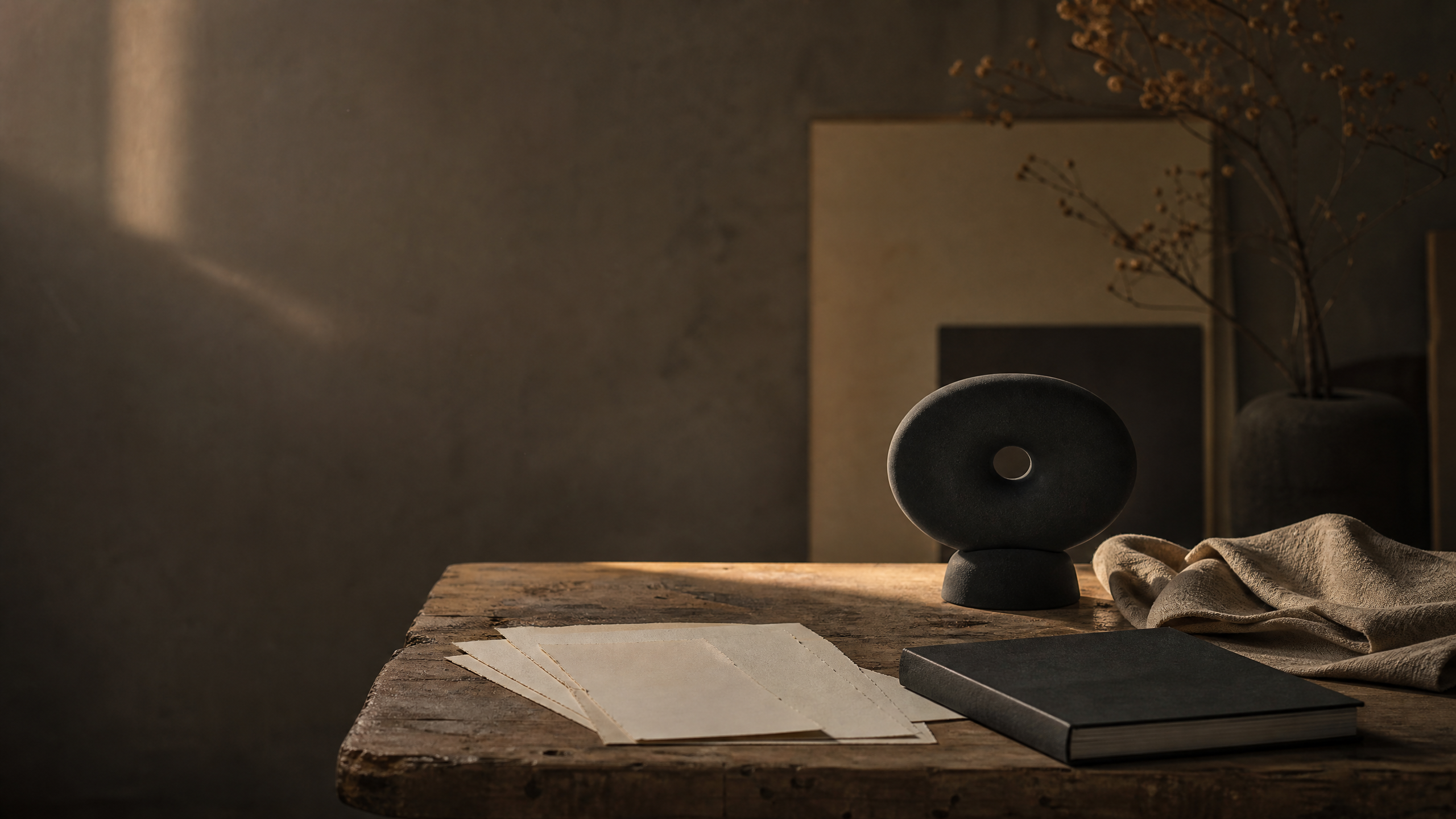 A warm editorial desk scene with paper, textured materials and an abstract sound object in soft shadow.